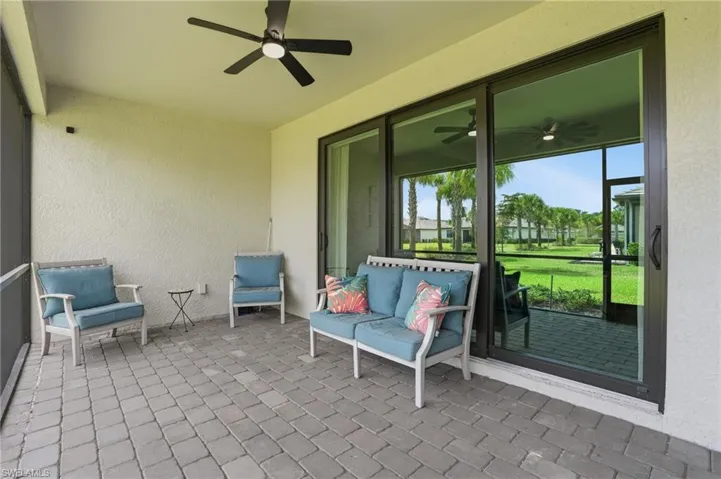View of patio with a ceiling fan and a sunroom
