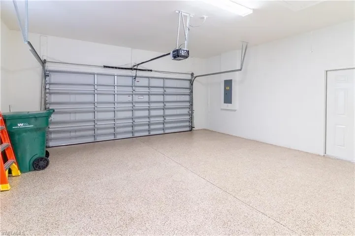 Garage with electric panel and a garage door opener