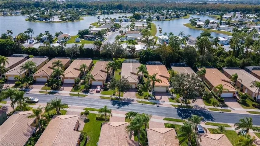 Aerial view of property and surrounding area with nearby suburban area and a large body of water