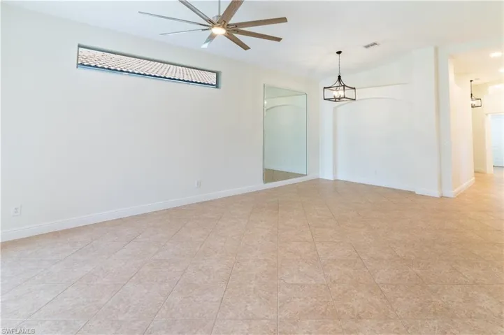 Empty room with ceiling fan and lofted ceiling