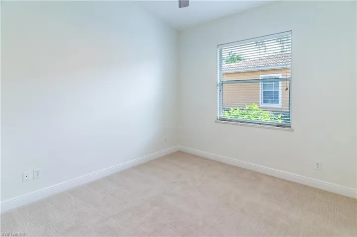 Empty room with light carpet and ceiling fan