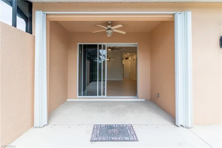 Property entrance with a patio, stucco siding, and ceiling fan