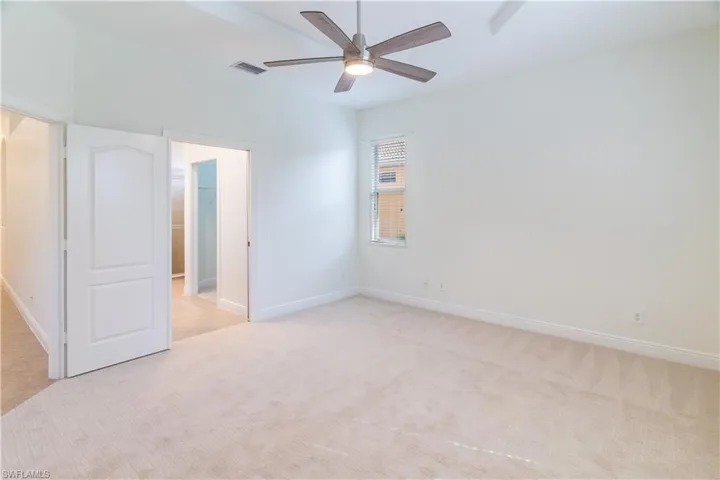 Unfurnished bedroom featuring light colored carpet and ceiling fan