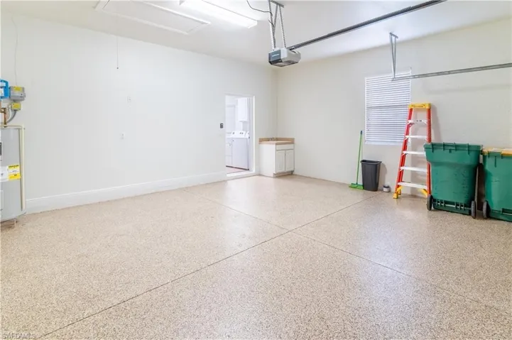 Garage featuring electric water heater and a garage door opener