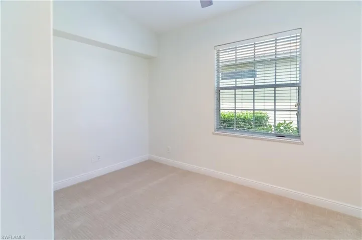Spare room featuring light colored carpet and baseboards