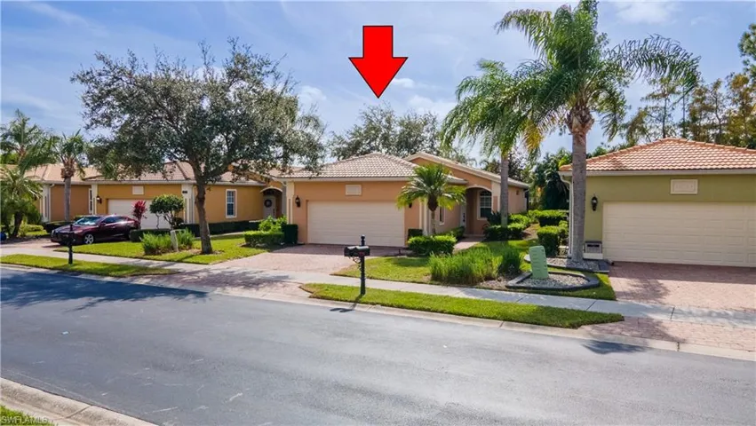 View of front of property featuring a tiled roof, stucco siding, and decorative driveway