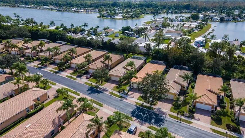 Aerial view of property and surrounding area featuring a large body of water and nearby suburban area