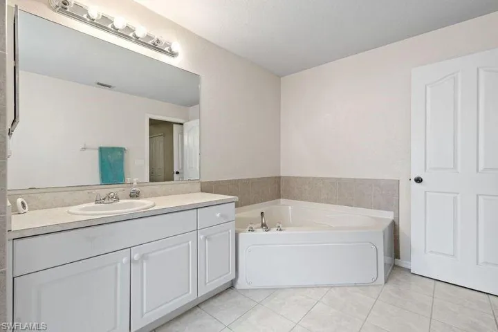 Master Bathroom featuring a washtub, tile patterned flooring, and vanity