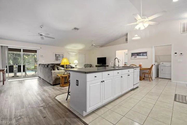 Kitchen featuring sink, white cabinetry and a large island for dining, homework and family gathering