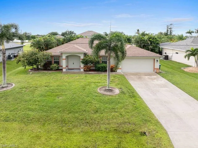 Front elevation of home featuring a garage and a front lawn