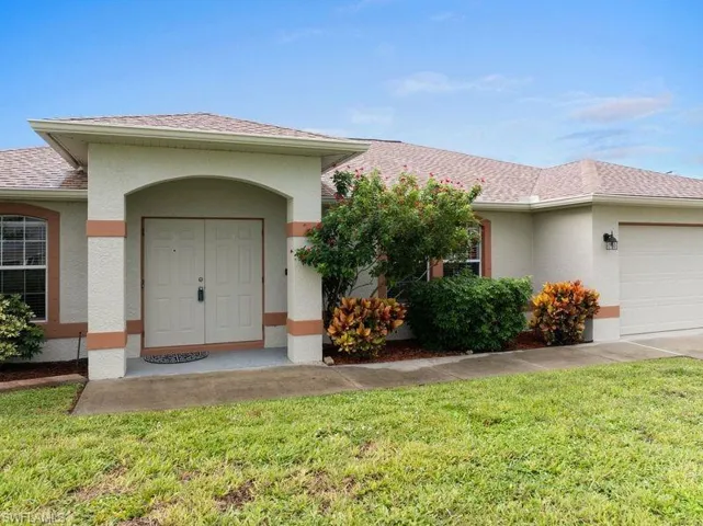 Property entrance featuring mature landscaping