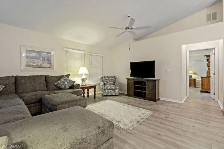 Living room featuring ceiling fan, vaulted ceiling, and light hardwood / wood-style flooring