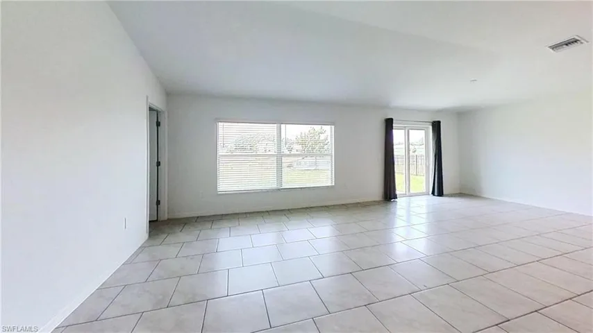 Spacious interior featuring neutral-toned tile flooring throughout