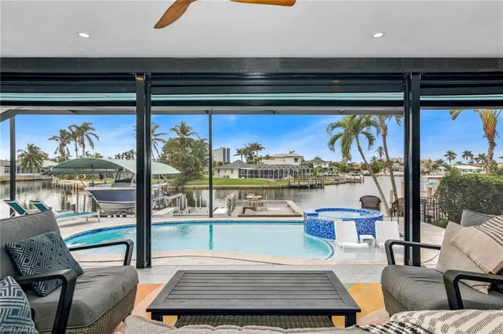 View of swimming pool with ceiling fan and a water view