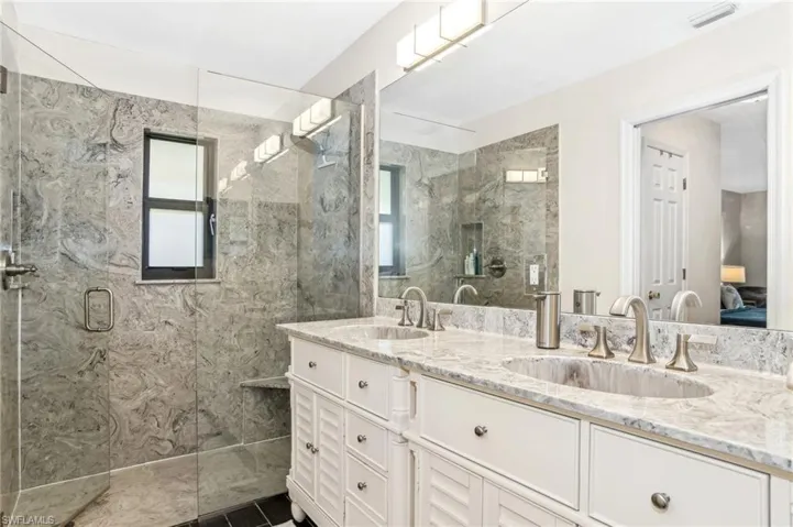 Bathroom with a wealth of natural light, vanity, and an enclosed shower
