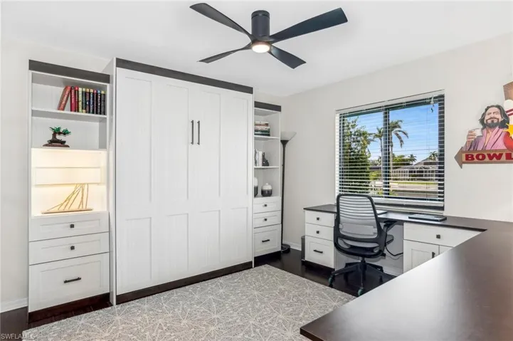 Home office featuring ceiling fan and dark wood-type flooring