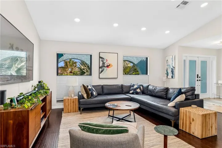 Living room featuring french doors, dark wood-type flooring, and lofted ceiling