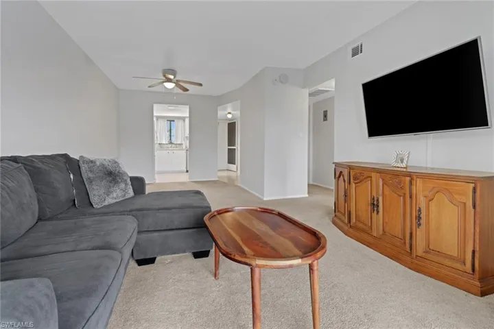Living room featuring ceiling fan and light carpet