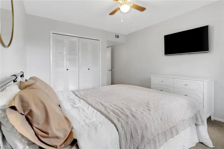 Bedroom with ceiling fan, a closet, and carpet