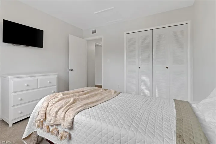 Bedroom featuring light carpet and a closet
