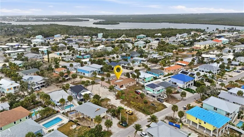 Aerial overview of property's location with a large body of water and nearby suburban area - Virtually Edited Image