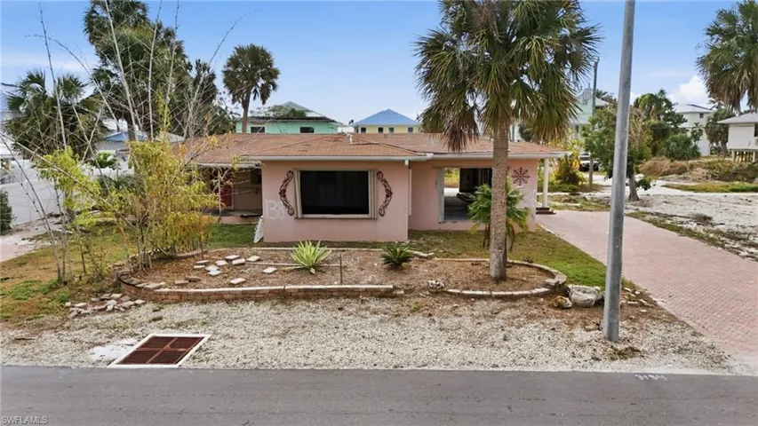 View of front of house featuring stucco siding and decorative driveway - Virtually Edited Image