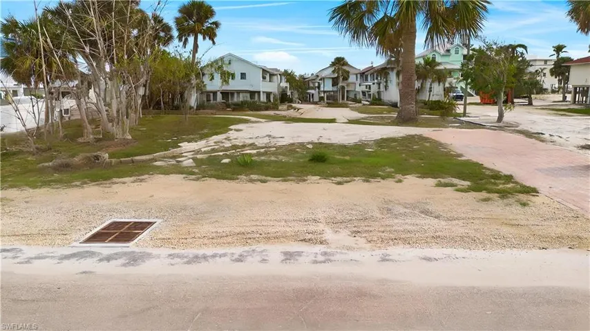 View of yard featuring visible vents, decorative driveway, and a residential view - Virtually Edited Image
