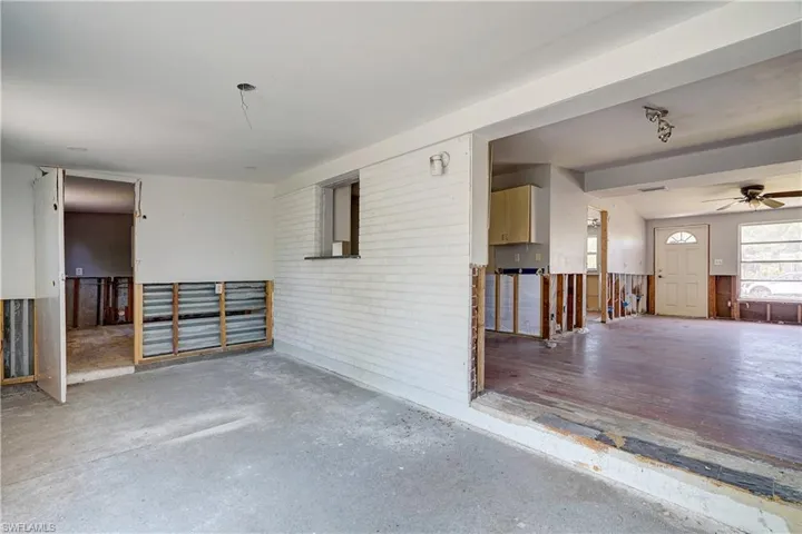 Spare room featuring ceiling fan, concrete floors, and brick wall