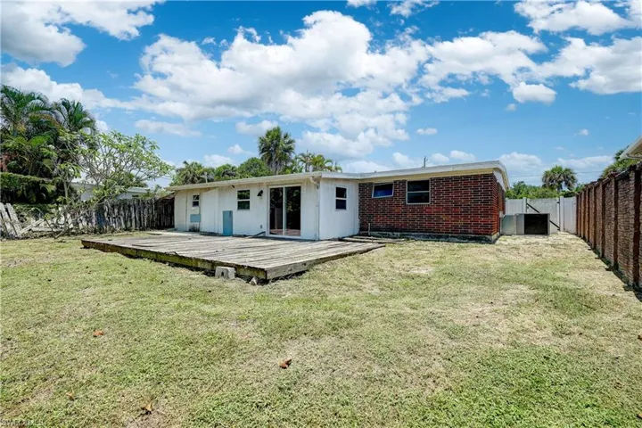 Back of house featuring a deck and a yard