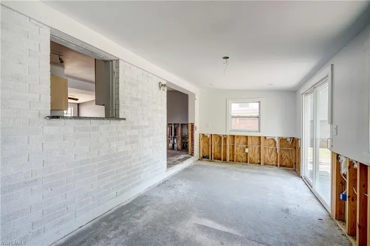 Empty room featuring brick wall and concrete flooring
