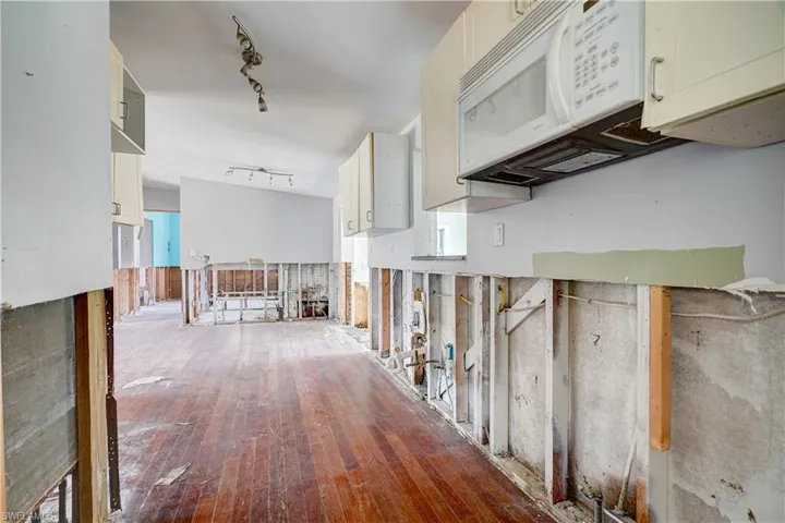 Hall with hardwood / wood-style flooring and rail lighting