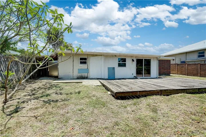 Back of property with a lawn and a wooden deck