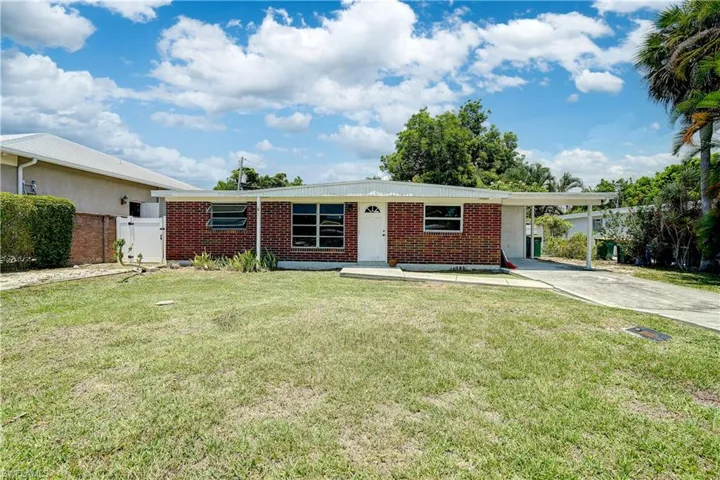 Single story home with a carport and a front yard