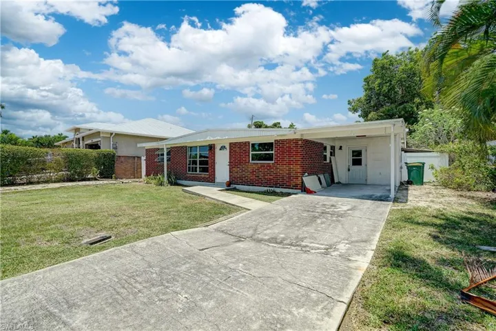 Ranch-style house with a front lawn and a carport