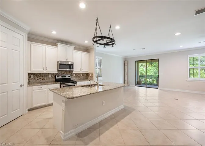 Kitchen featuring a kitchen island with sink, sink, a healthy amount of sunlight, and appliances with stainless steel finishes