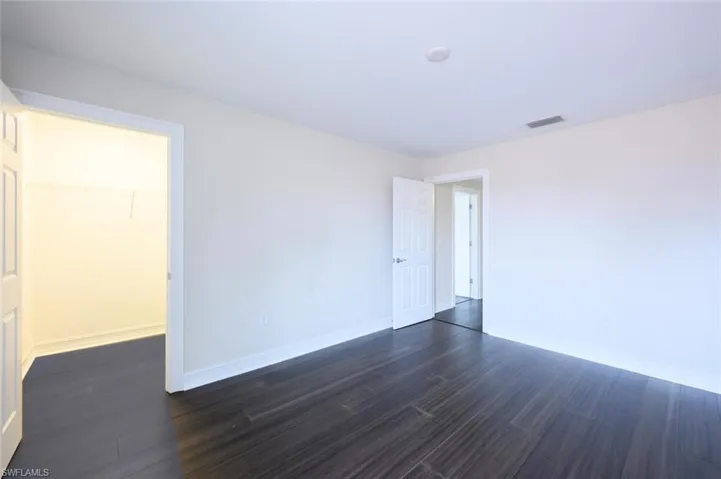 Empty room with dark hardwood / wood-style flooring