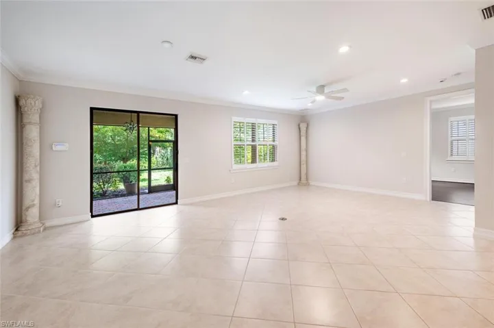 Tiled spare room featuring ceiling fan and ornamental molding