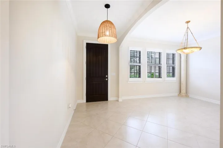 Tiled entryway featuring ornamental molding