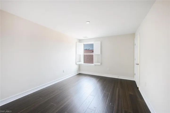 Unfurnished room featuring dark hardwood / wood-style flooring