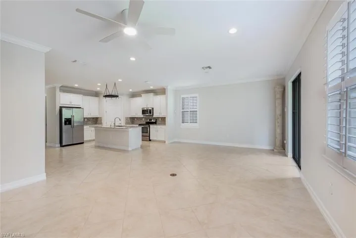 Unfurnished living room with plenty of natural light, ornamental molding, and sink