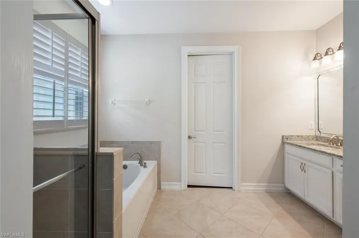 Bathroom with tile patterned flooring, vanity, and a bath