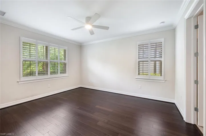 Spare room featuring ceiling fan, dark hardwood / wood-style flooring, and ornamental molding