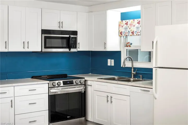Kitchen featuring appliances with stainless steel finishes and white cabinets