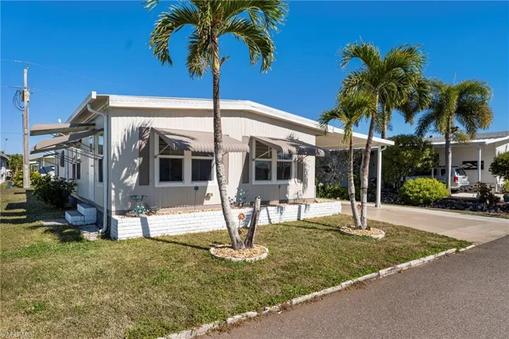Manufactured / mobile home with a front lawn and concrete driveway