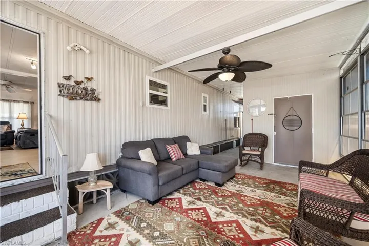 Living room with ceiling fan and concrete flooring