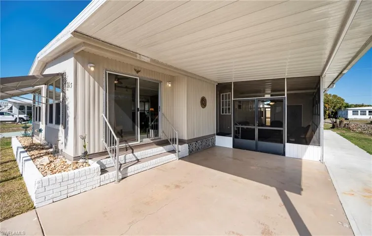View of patio / terrace featuring an attached carport and a sunroom