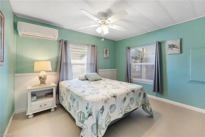 Bedroom featuring a wall unit AC and ceiling fan