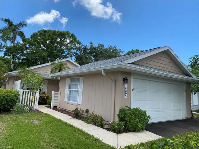 View of property exterior with roof with shingles, a garage, and asphalt driveway