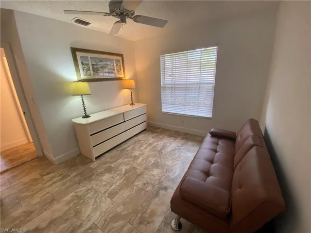 Living area featuring a textured ceiling and a ceiling fan