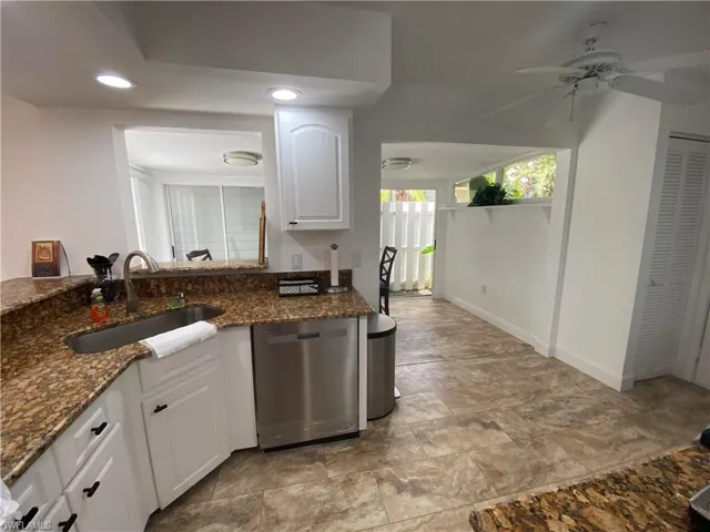 Kitchen featuring dishwasher, white cabinetry, dark stone countertops, recessed lighting, and ceiling fan